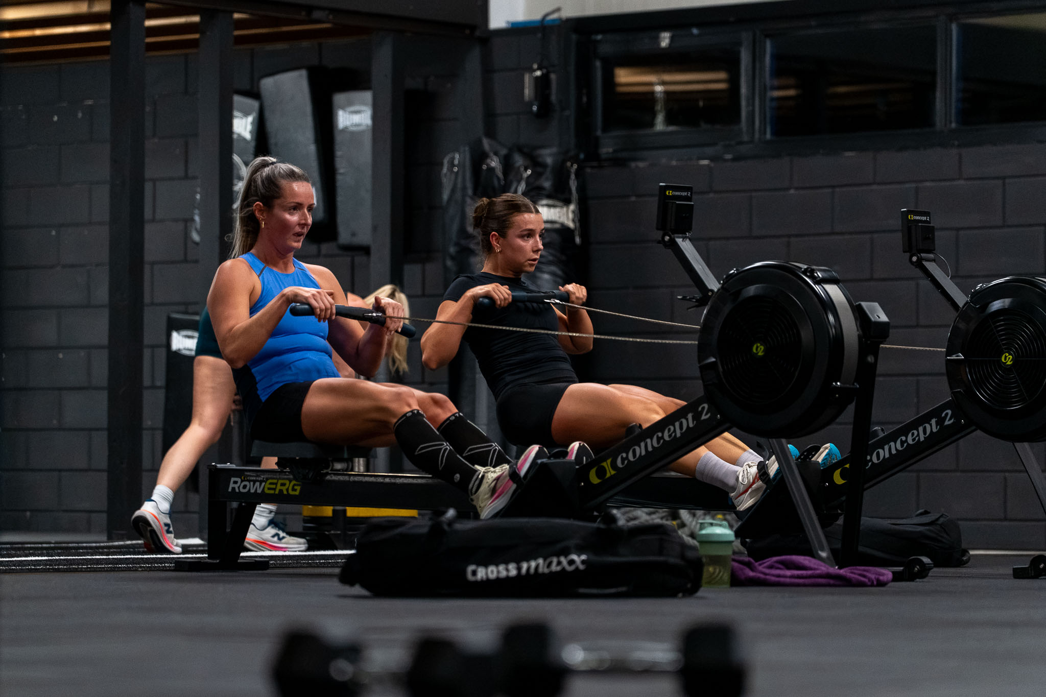 Twee vrouwen trainen op de roeimachine bij CLC Sports